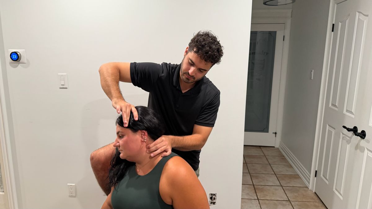 Dr. Alex providing an assisted neck stretch for headaches during a home visit
