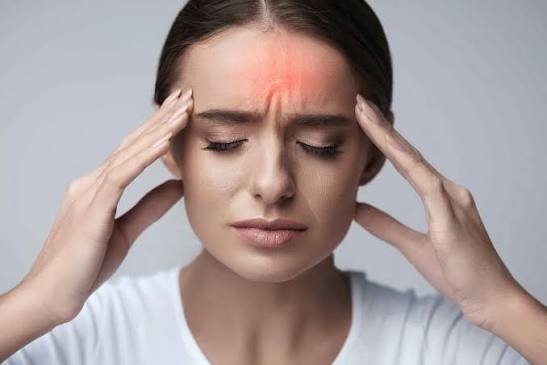Woman holding her temples with a headache, a common reason for headache treatment in Oakville