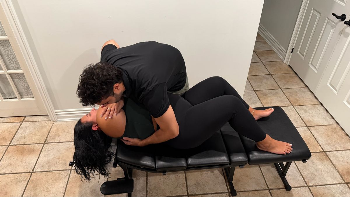 Dr. Alex performing a mid-back adjustment for shoulder pain during a home visit