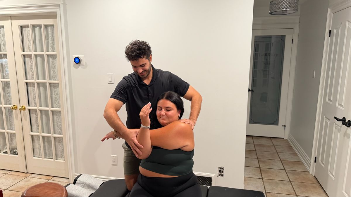 Soft tissue therapy on the shoulder during a home visit in Oakville